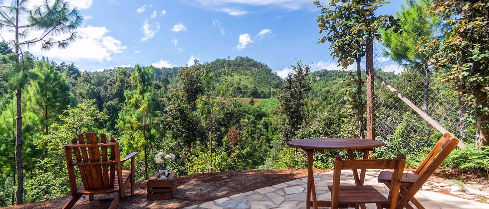 A chair and table overlooking the forested valley